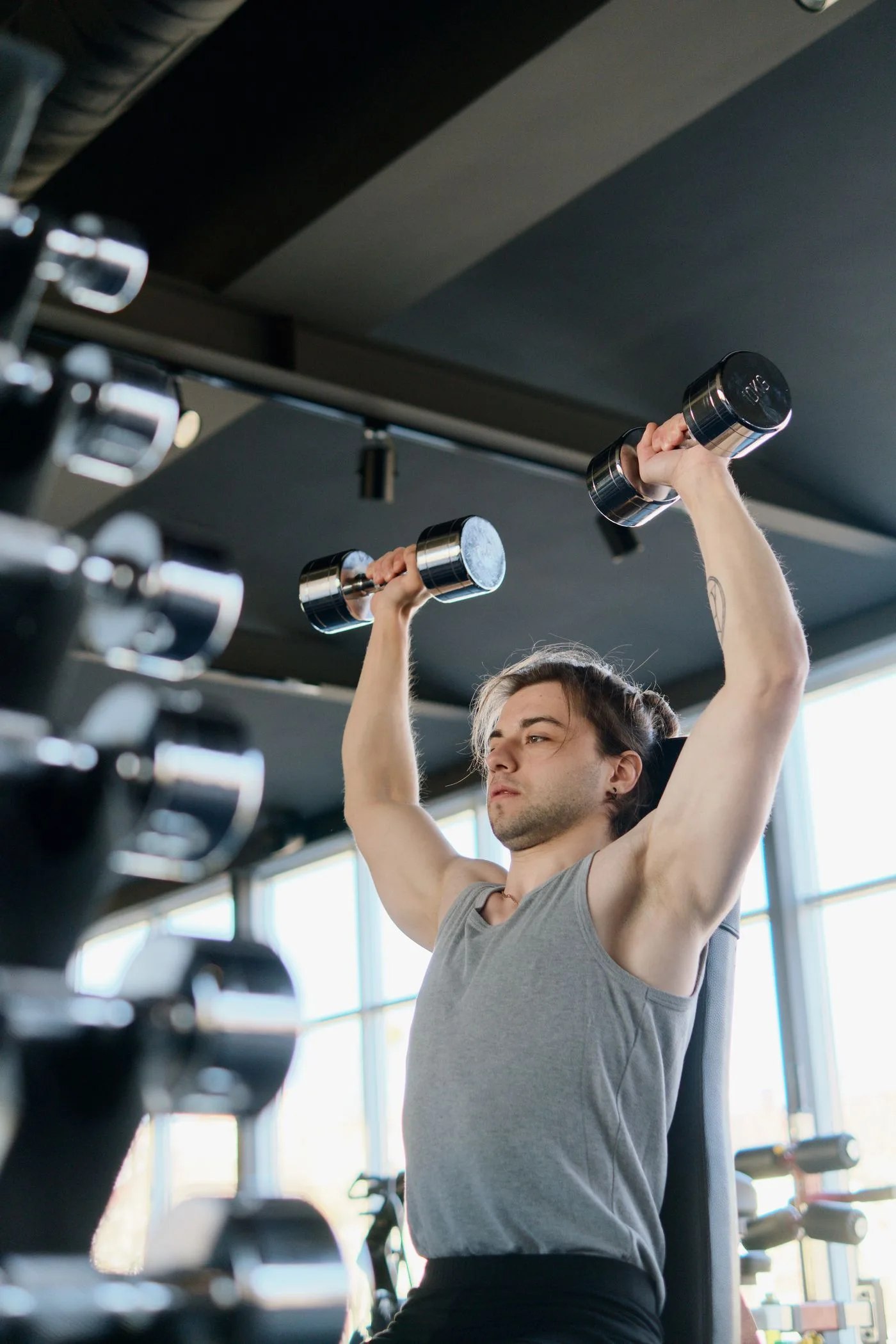 A person performing a dumbbell shoulder press